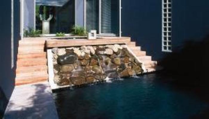 Outdoor pool with rock wall water feature